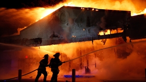 Firefighters work on extinguishing a burning restaurant in Ferguson after rioting erupted in the wake of the grand jury decision