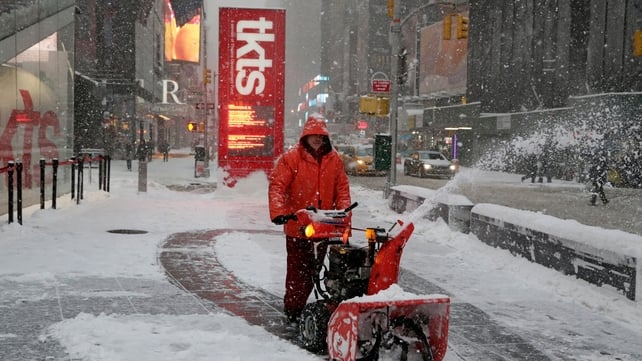 A worker clears the street in front of the TKTS booth in Times Square while heavy snow falls in New York A worker clears the street in front of the TKTS booth in Times Square while heavy snow falls in New York