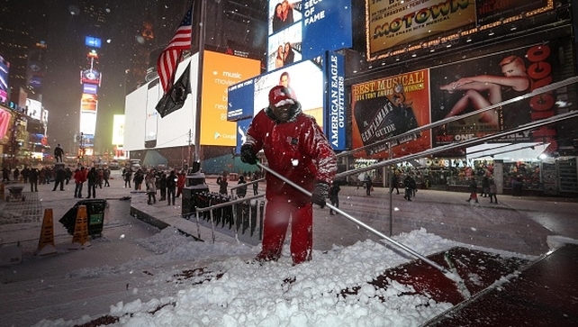 Worker removes the snow on a street following road closures in Times Square Worker removes the snow on a street following road closures in Times Square