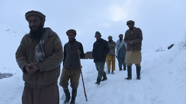 Relatives walk down from the site after searching for the victims of avalanches in the district of Bazarak Relatives walk down from the site after searching for the victims of avalanches in the district of Bazarak