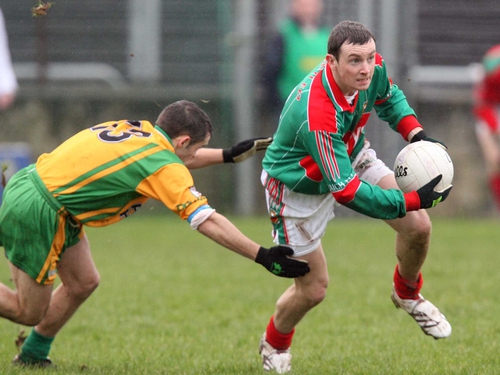 Keith Higgins of Mayo goes around Kevin McMenamin during their league meeting in February