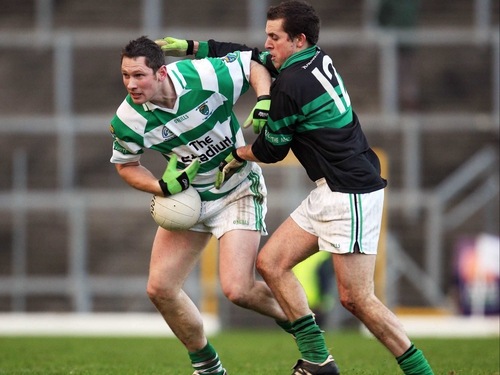 Alan Cronin of Nemo Rangers gets a hand in on Ballinacourty's Gary Hurney