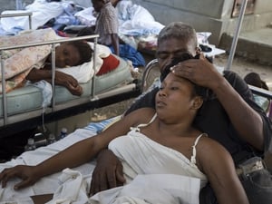 A man comforts his injured wife in a medical centre struggling for supplies