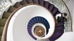 A classy spiral staircase weaves through three floors