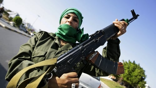 A Libyan female member of Muammar Gaddafi's forces guards a checkpoint at a street in Tripoli