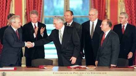 Franjo Tudjman (centre) shakes hands with Slobodan Milosevic