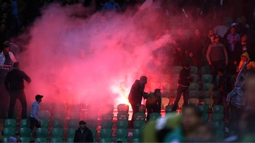Flares are thrown in the stadium during clashes