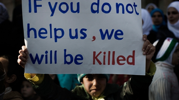 A young boy holds up a sign during an anti-regime demonstration in the Syrian village of al-Qsair