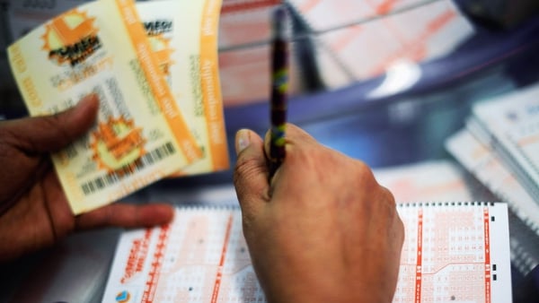 A woman fills out a Mega Millions lottery ticket form in California