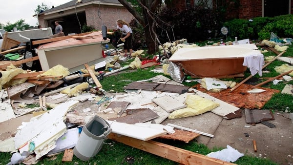 Residents search for personal belongings after a tornado destroyed their home in Arlington