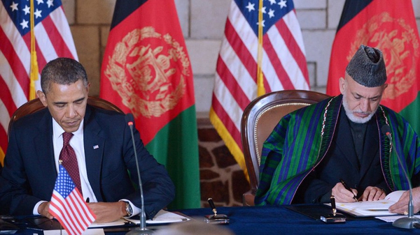 Barack Obama and Hamid Karzai sign the partnership deal at Mr Karzai's palace in Kabul