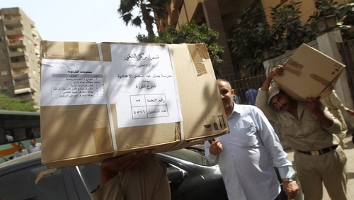 Egyptian soldiers carrying boxes containing voting ballots in the capital Cairo