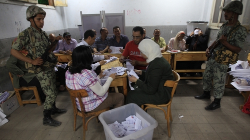 Officials open a ballot box to count the votes at a polling station in Cairo