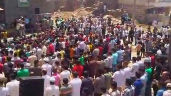 People gather at site in Houla where the massacre took place