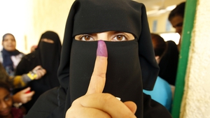 An Egyptian women shows her ink-stained finger after voting at a polling station in Cairo