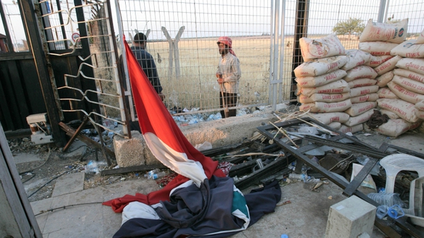 Free Syrian Army soldiers stand near a fallen Syrian flag at the Bab al-Salam border crossing to Turkey yesterday