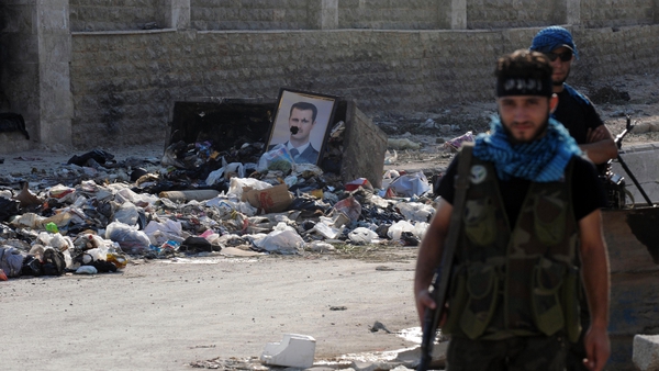 Opposition fighters guard a checkpoint during clashes with forces loyal to Mr Assad in Aleppo