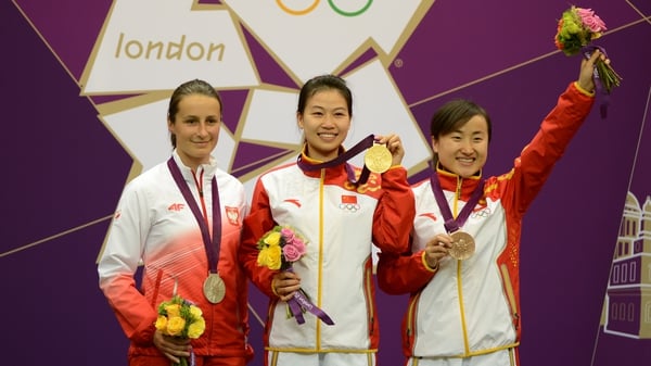 China's Yi Siling (c) celebrates with her gold medal next to compatriot Yu Dan (r) and Poland's Sylwia Bogacka
