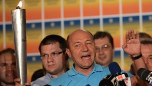Romanian President Traian Basescu holds The Democracy Torch as he addresses reporters