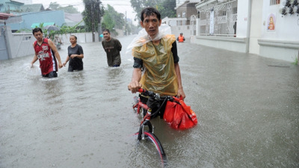A resident pushes his bicycle through murky floodwaters in Quezon City in suburban Manila