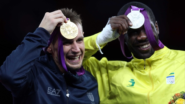Carlo Molfetta of Italy shows off his gold medal, while Anthony Obame shows off Gabon's first ever Olympic medal