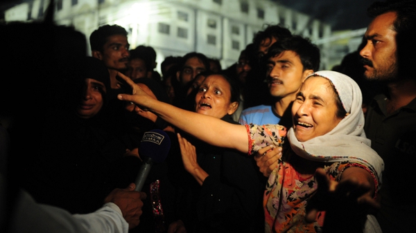 Relatives of the victims gathered outside the factory in Karachi