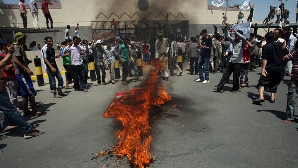 Yemeni protesters gather around a fire during a demonstration outside the US embassy in Sanaa