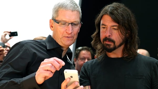 Apple CEO Tim Cook shows musician Dave Grohl the iPhone 5