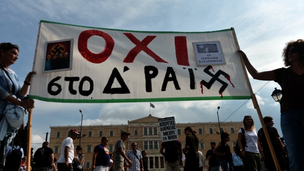 Protesters hold a banner reading 'No to the Fourth Reich' outside the parliament in Athens