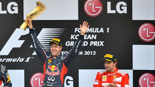 Sebastian Vettel (l) celebrates on the podium alongside third-placed Fernando Alonso