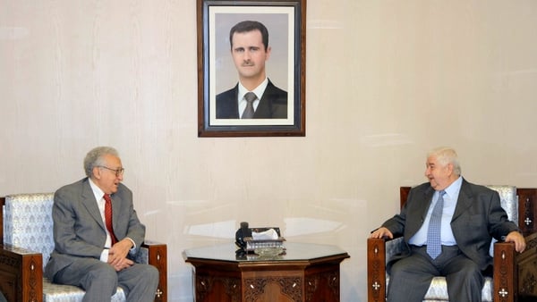 Syrian Foreign Minister Walid Muallem (R) speaks with international peace envoy Lakhdar Brahimi during a meeting in Damascus