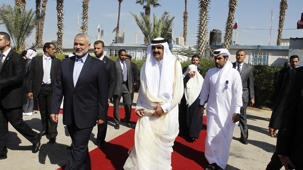 Qatari Emir Sheikh Hamad bin Khalifa al-Thani (r) walks alongside Gaza's Hamas prime minister Ismail Haniyeh (l) during a welcome ceremony at the Rafah border crossing with Egypt