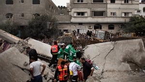 Palestinian firefighters and rescue personnel work at a blast site following an Israeli air raid in Gaza