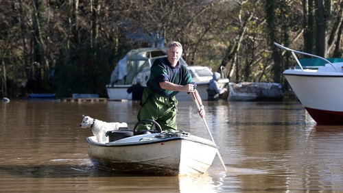 A man uses his boat to get through flood water that has covered the car park of Portavon Marina, in Keynsham, England