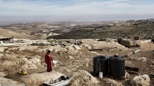 A Bedouin woman walks at her camp in the E1 area, between Jerusalem and the Israeli West Bank settlement of Maale Adumim