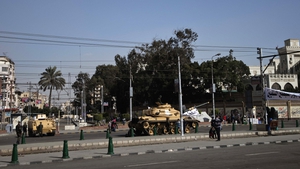 An Egyptian armoured personnel carrier and tank are deployed outside the presidential palace in Cairo
