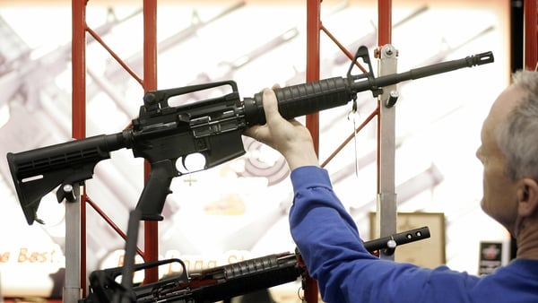 A customer at a gun show in Milwaukee examines a Bushmaster assault rifle similar to the one used in the Sandy Hook shootings