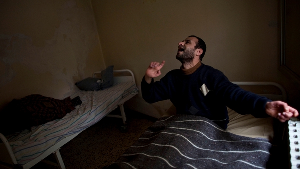 A Syrian patient sits in a bed at Dar Al-Ajaza psychiatric hospital in the heart of the Old City of Aleppo