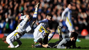 Paul Green of Leeds hurdles the grounded Gareth Bale