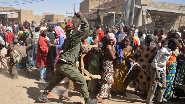 A Malian soldier tries to disperse looters in the streets of Timbuktu