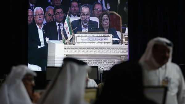 Moaz Alkhatib appears on a screen as he addresses the opening of the Arab League summit in the Qatari capital Doha