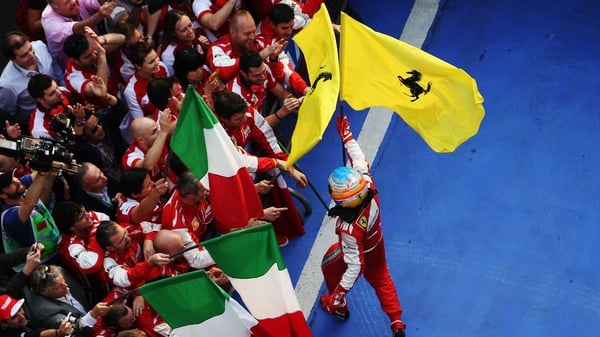 Fernando Alonso of Spain and Ferrari celebrates in parc ferme with teammates after winning the Chinese Grand Prix at the Shanghai International Circuit