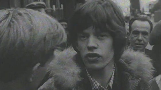 Mick Jagger speaking to reporter Mike Burns as the Rolling Stones arrive to play Dublin in 1965.