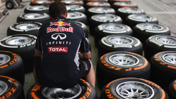 A Red Bull Racing mechanic works on wheels and Pirelli tyres in the paddock ahead of the Bahrain GP