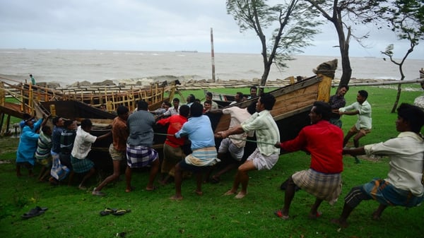 Bangladeshis shift a boat away from the beachfront as the cyclone heads towards landfall