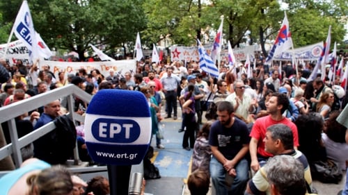 People gather outside the headquarters of the Greek public broadcaster ERT in support of staff