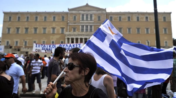 A woman holds a Greek flag in front of parliament buildings in Athens during a recent general strike