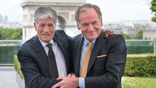 Publicis Group CEO Maurice Levy (L) embraces Omnicom Group CEO John Wren during a press conference in Paris