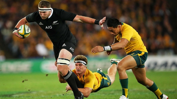 Kieran Read of the All Blacks breaks the tackle of Michael Hooper and Christian Lealiifano of the Wallabies