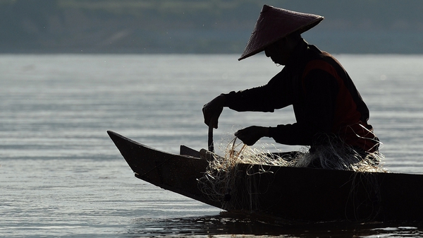A fisherman on the Mekong river, proposed site of 11 hydroelectric dams